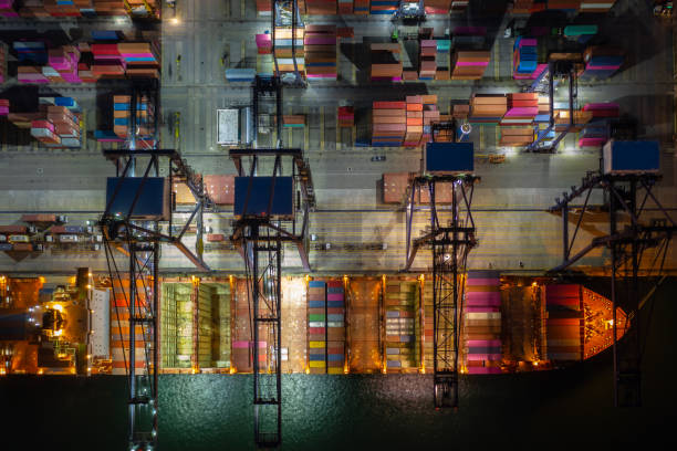 istock Container ship loading and unloading in deep sea port, Aerial view at night 1363774784