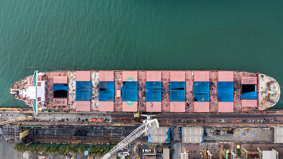 Aerial top view container ship in shipyard for repair maintenance in Thailand