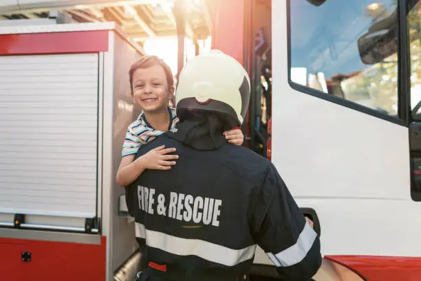 Photo of Fireman showing the truck to his son