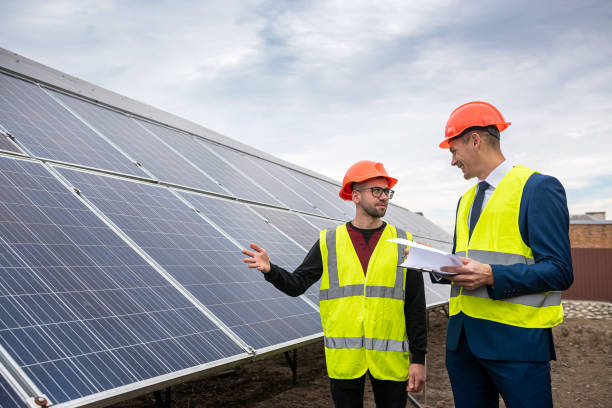 istock tall men in work clothes are considering whether to install solar panels in the open air. 1363777970
