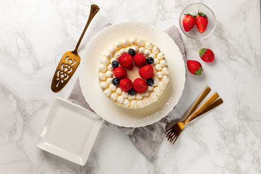 Delicious cheesecake with fresh strawberries and blueberries without baking on marble table