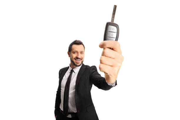 istock Smiling man in a suit and tie holding a vehicle key 1363779836