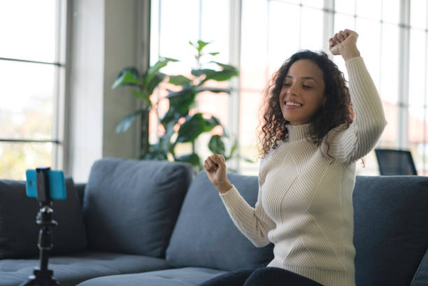 istock Young African American women live streaming dancing on the sofa through the application from smartphone to social media during the coronavirus outbreak. 1363781475