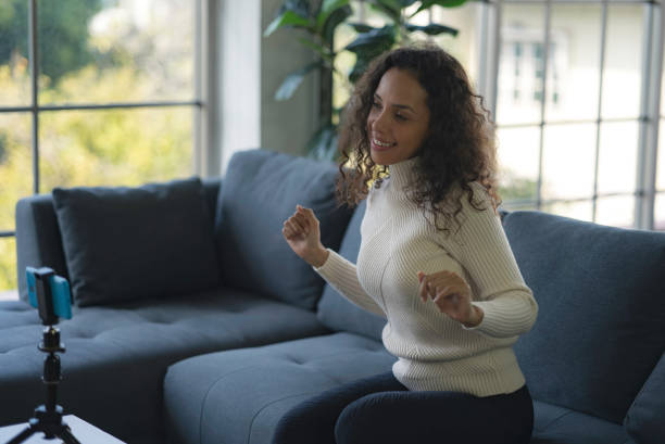 istock Young African American women live streaming dancing on the sofa through the application from smartphone to social media during the coronavirus outbreak. 1363781480