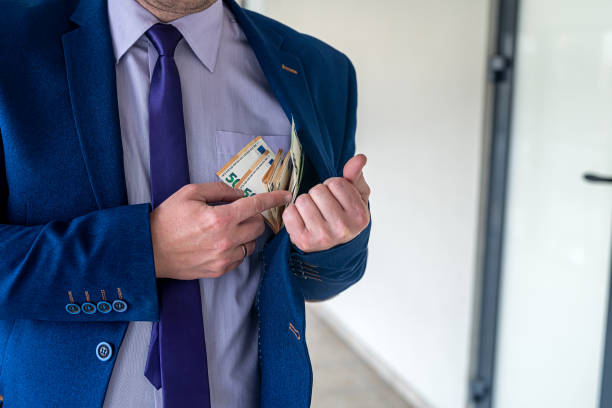 istock Businessman putting euro bills into pocket hit jacket 1363782649