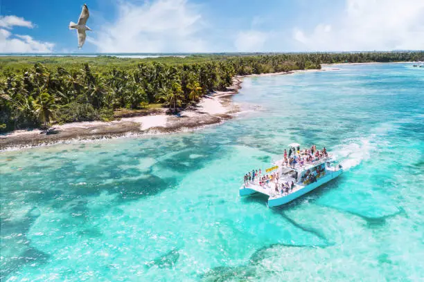 Photo of aerial view of a boat on excursion from La Romana to Saona via Punta Cana heading along beautiful caribbean beaches, Dominican Republic