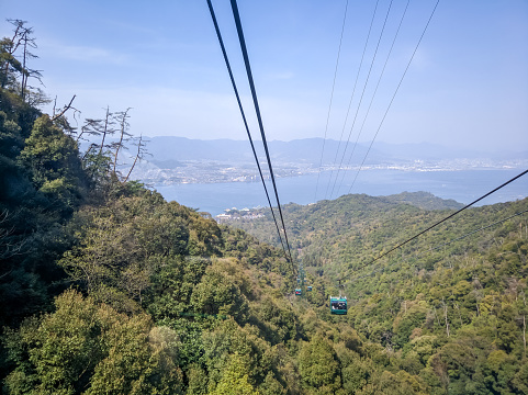 Cable car to Mount Misen, height 535 meters, Miyajima island. Cable car cabins against the backdrop of the greenery of Miyajima Island.