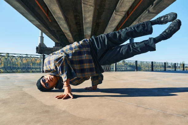 istock Young man break dancer dancing on urban background performing acrobatic stunts 1363789742
