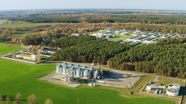 istock Aerial View Modern Granary, Grain-drying Complex, Commercial Grain Or Seed Silos And chicken farm In Sunny Rural Landscape. Corn Dryer Silos, Inland Grain Terminal, Grain Elevators In Field 4K 1363792935