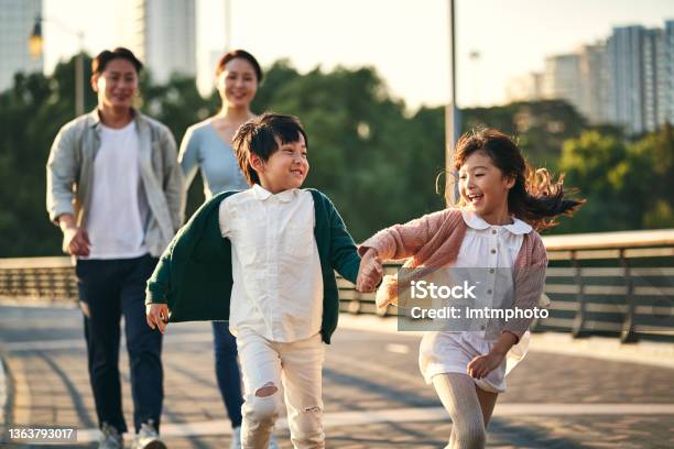 Asian Family With Two Children Taking A Walk In City Park Stock Photo - Download Image Now