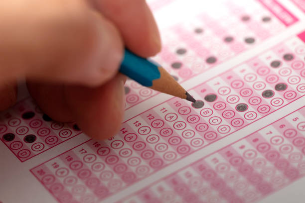istock hand fill in Exam carbon paper computer sheet and pencil 1363794695