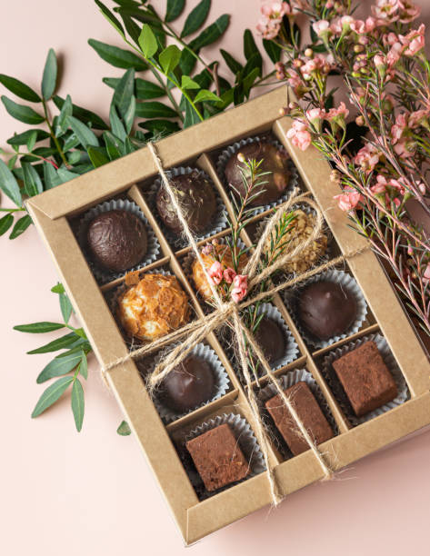 istock Gift craft box with assorted chocolates and pink flowers on a light concrete background. Top view. 1363794970