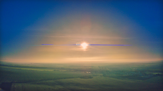 Thick clouds of fog cover the morning sun. The anamorphic lens creates these blue flares when looking directly into the sun.