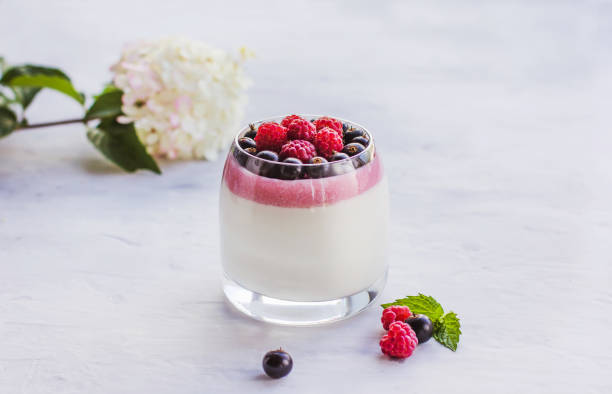 dessert italiano panna cotta salsa ai frutti di bosco - yogurt yogurt container strawberry spoon foto e immagini stock