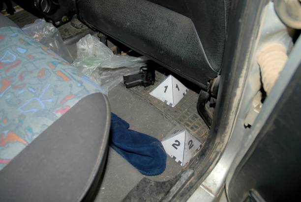 l’inspection visuelle de csi à l’intérieur d’une voiture a trouvé une arme à feu, une arme à feu, un pistolet, marqués avec des cônes de police - csi photos et images de collection