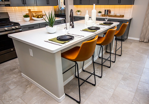Kitchen Island With Decorative Place Settings And Leather Bar Stools