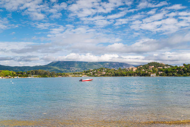 istock Anchored boat on sea surface against Corfu under blue sky 1363800401