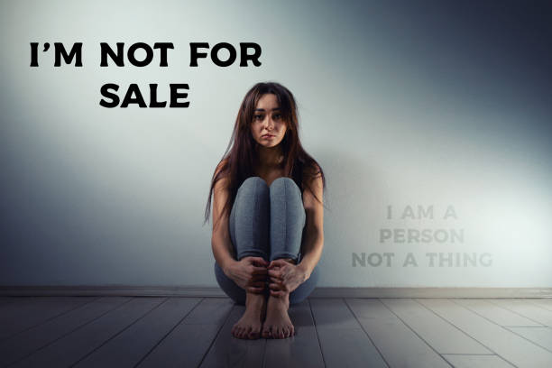 A young sad woman sits disheveled on the floor of a room. There is a light wall in the background.Human trafficking, sexual slavery concept. The inscription I'm not for sale A young sad woman sits disheveled on the floor of a room. There is a light wall in the background.Human trafficking, sexual slavery concept. The inscription I'm not for sale. Trafficking stock pictures, royalty-free photos & images