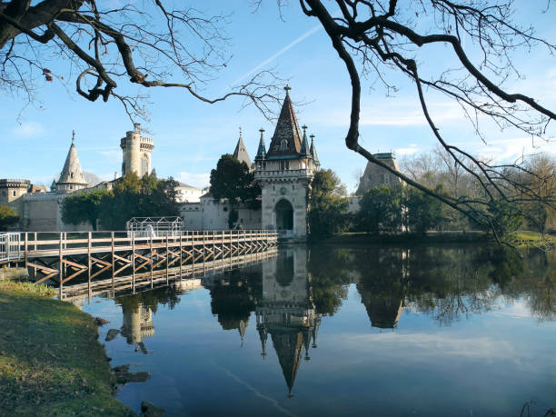 Laxenburg, Austria - January 02, 2022: Castle pond with a walkway for visitors to Franzensburg Castle with reflection in the lake, a small ferry operates in the warmer months. The public park is a preferred destination near Vienna