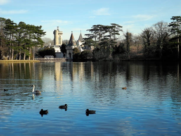 Laxenburg, Austria - January 02, 2022: Castle pond with a walkway for visitors to Franzensburg Castle with reflection in the lake, a small ferry operates in the warmer months. The public park is a preferred destination near Vienna