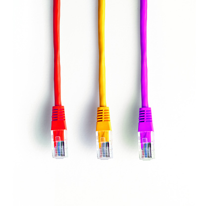 Colorful LAN cables with plugs against white background