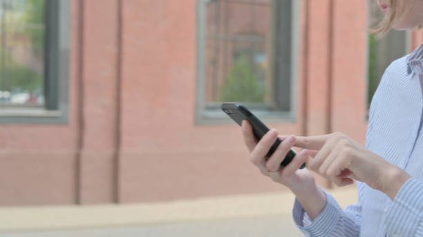 istock Close up of Walking Woman Using Smartphone 1363808264