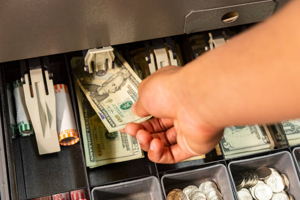 une main plaçant de l’argent dans un tirage au sort - cash box photos et images de collection