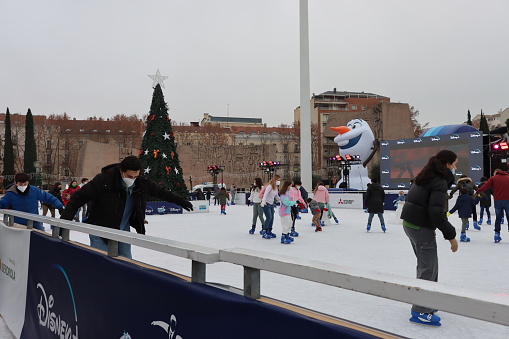 Madrid - Spain - January 4, 2022. \nFamilies ice skating at the central Plaza Colon.