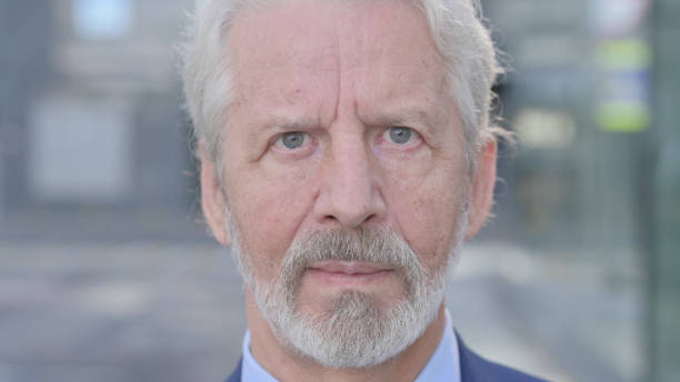 istock Face Close up of Old Businessman Looking at Camera 1363809907