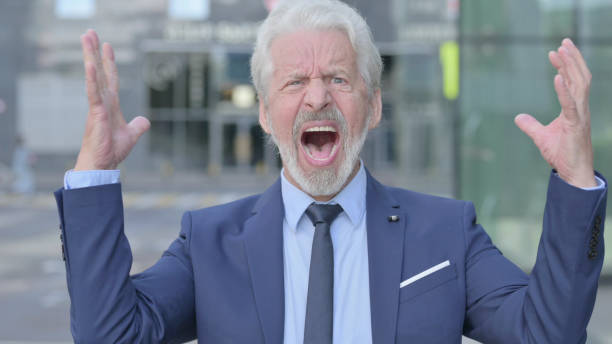 istock Old Businessman Screaming, Shouting while Standing Outdoor 1363810060