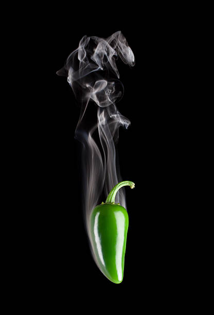 Long green chili pepper placed on a white surface