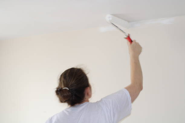 istock woman painting her house 1363816059