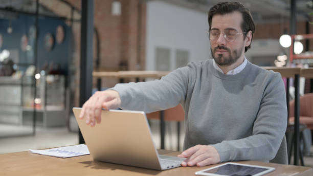 istock Young Man Closing Laptop and Leaving Cafe 1363817318