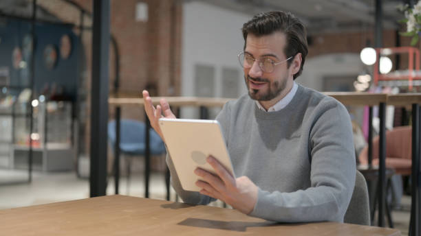 istock Young Man Doing Video Call on Tablet in Office 1363817401