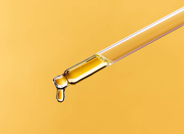 istock serum pipette close-up with falling drop on golden background 1363818677