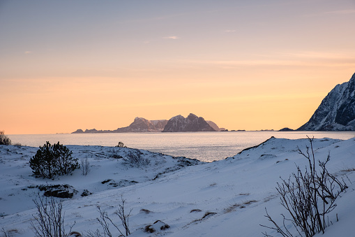 Scenery of mountain with snow pile on coastline in the evening on winter at Nordland, Lofoten Islands, Norway