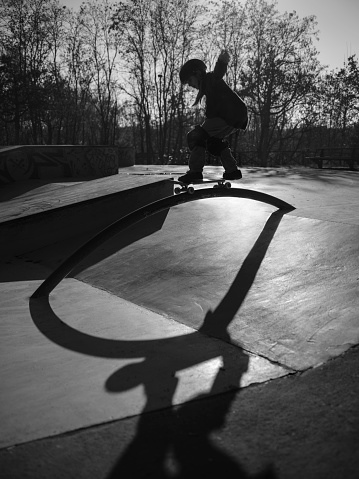 Skater performing in a concrete skatepark at sunset
