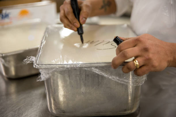 Labeling prepared food A rectangular metal food container is covered with clear wrap. An unrecognizable person is labeling the food with a permanent marker permanent marker photos stock pictures, royalty-free photos & images