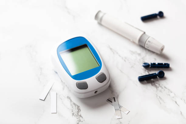 glucometer ketometer lancet and strips for self-monitoring of blood glucose or ketones level. diabetes or keto diet stock photo