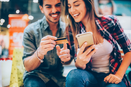 Smiling couple shopping online with credit card