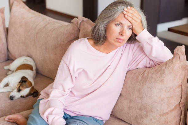 istock Sad pensive middle age woman looking down depressed sitting on the sofa 1363829359