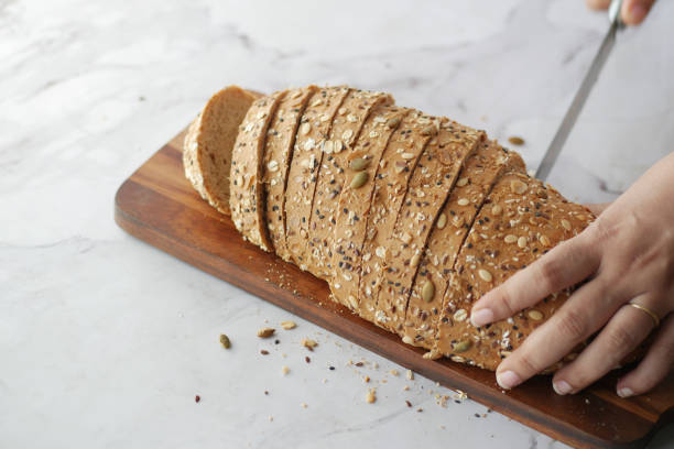 istock Women hand cutting baked brow bread on table. 1363830216