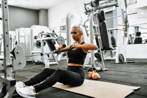 istock Blond Female Athlete Using Seated Row Machine For Gym Workout 1363831202