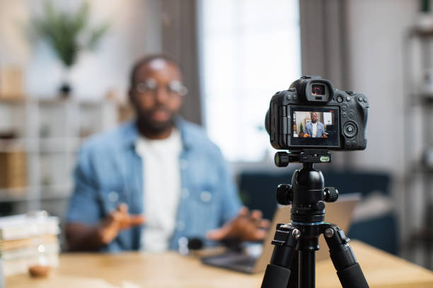 istock African guy recording new video blog on digital camera 1363832314