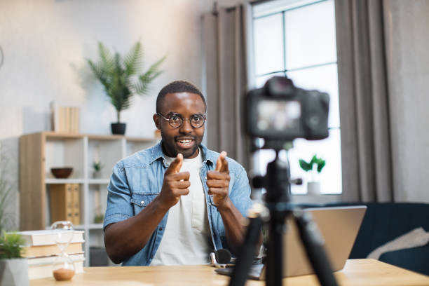 istock Positive guy recording video blog on camera at home 1363832379