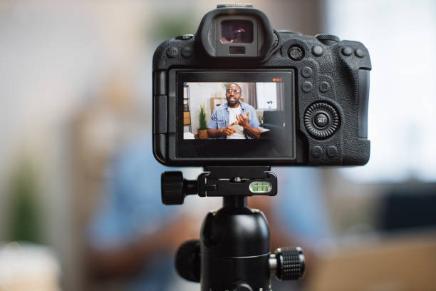 istock Close up of digital camera with african blogger on screen 1363832392
