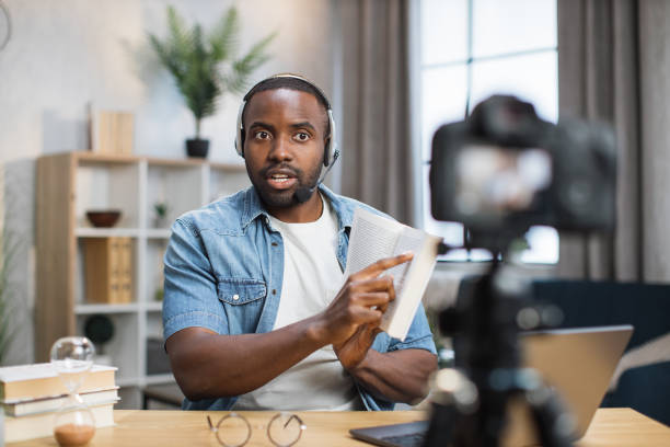 istock Focused african man in headset recording video lesson 1363832457
