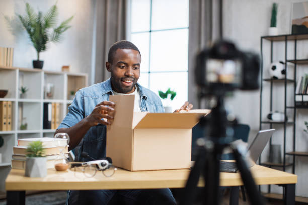 istock Man filming on camera unpacking process of paper box 1363832539