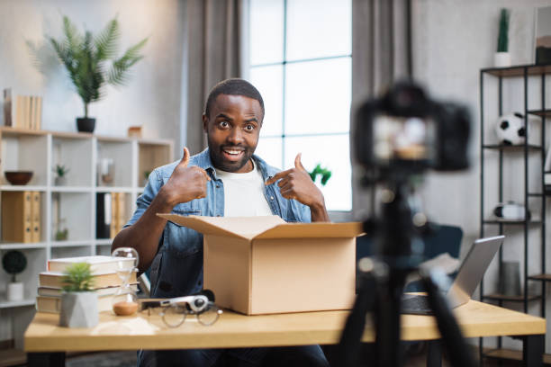 istock Man filming on camera unpacking process of paper box 1363832551