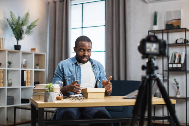 istock African man recording video while unboxing present 1363833161
